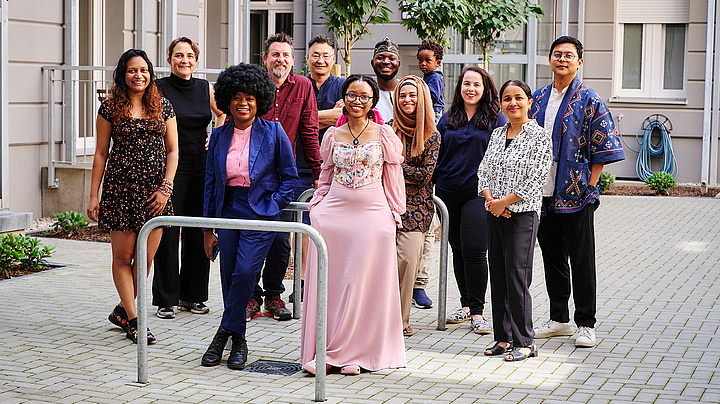 Gruppenbild der Teilnehmenden des Humboldt Residency-Programms vor einem modernen, hellen Gebäude